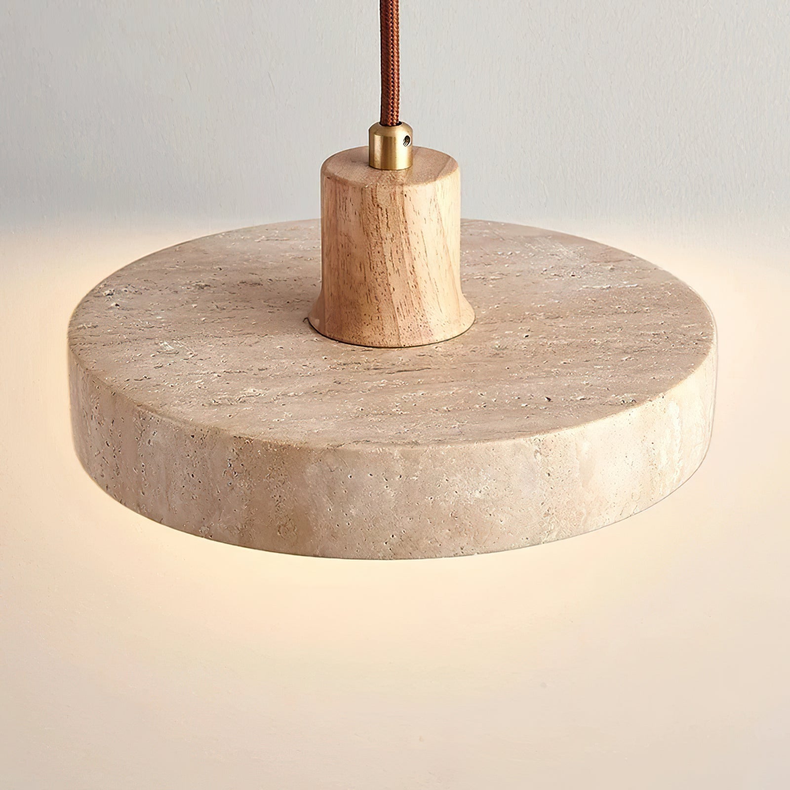 Top view of round travertine shade with a light wooden stem