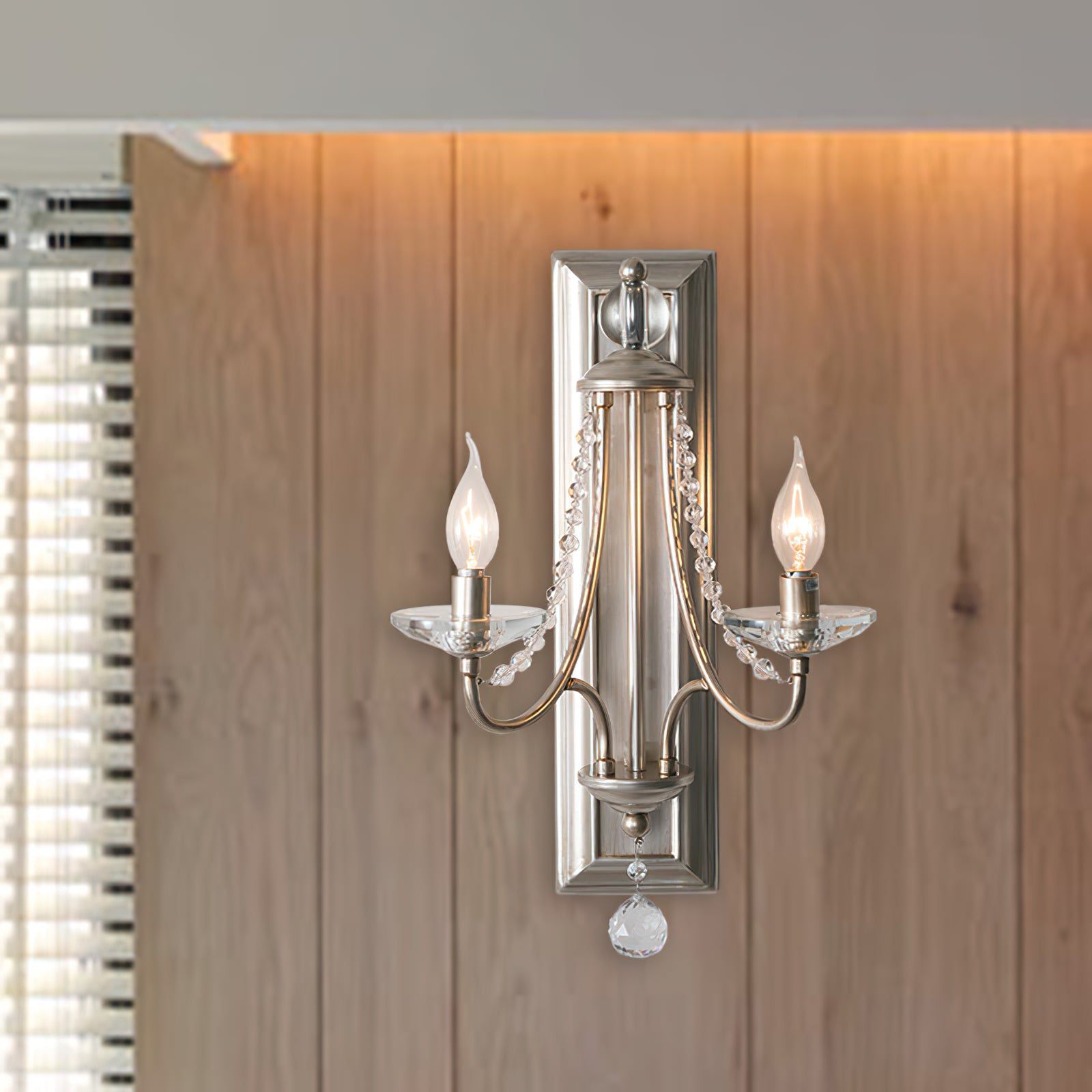 Silver-finish crystal sconce against a wood-paneled wall