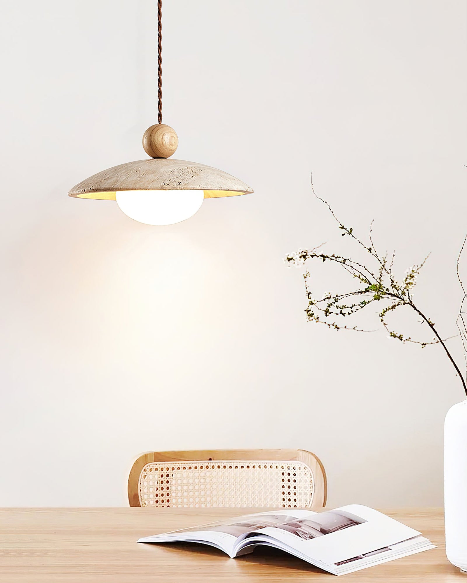 Light wood-sphere travertine pendant above an open book