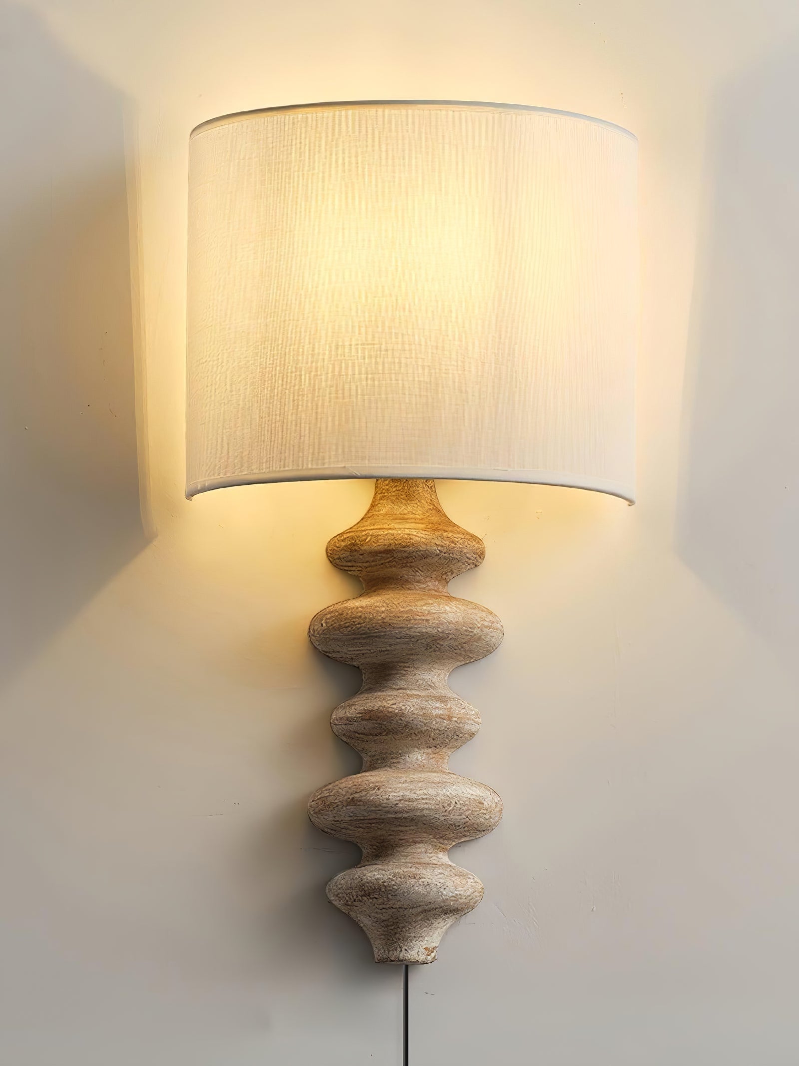 Wood-finish shaded wall lamp with a visible lower cord