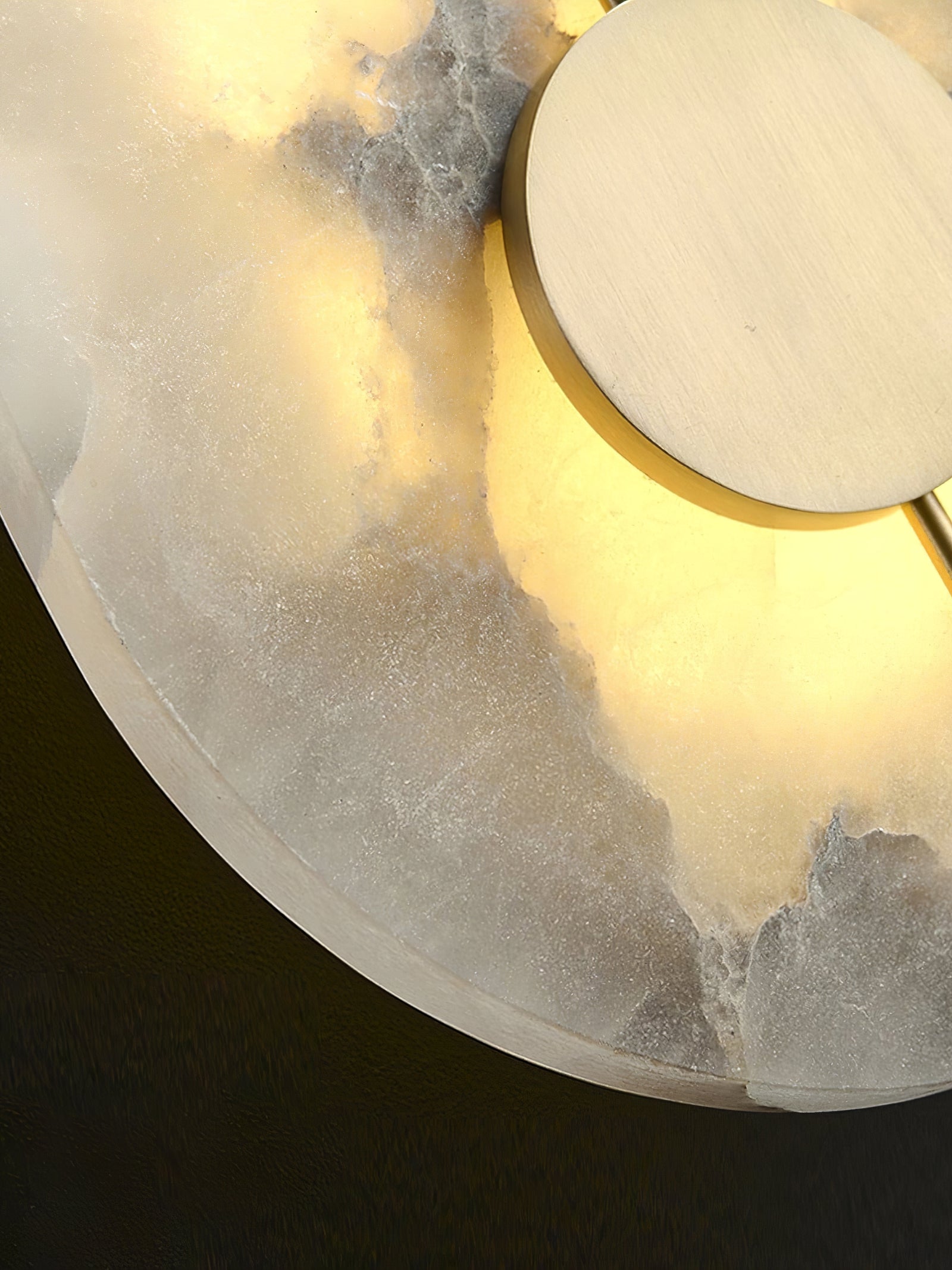 Close-up of brass disc and illuminated marble veining