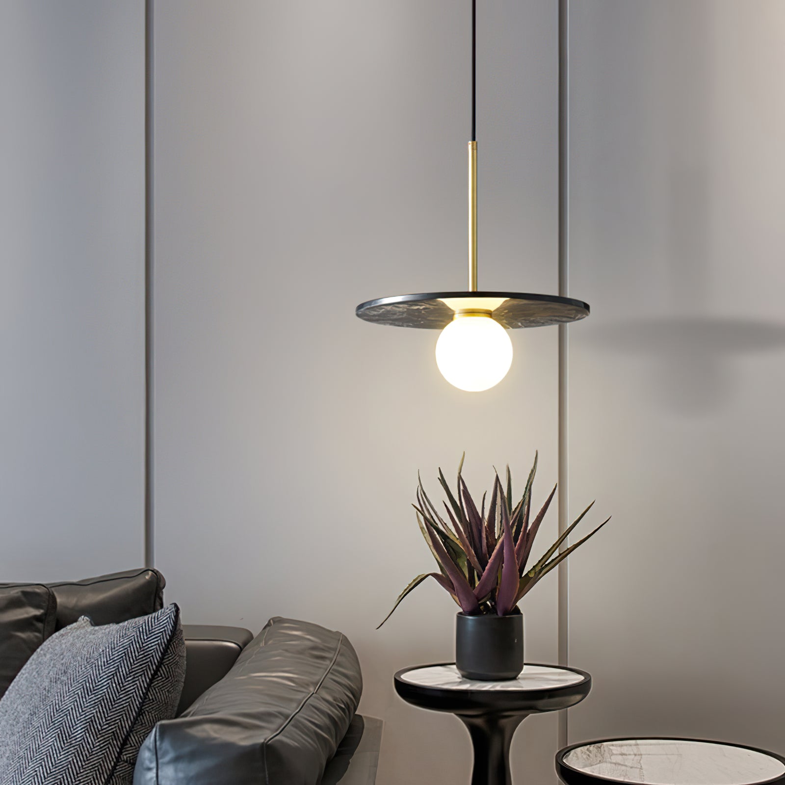 Dark veined marble pendant above a side table beside a sofa