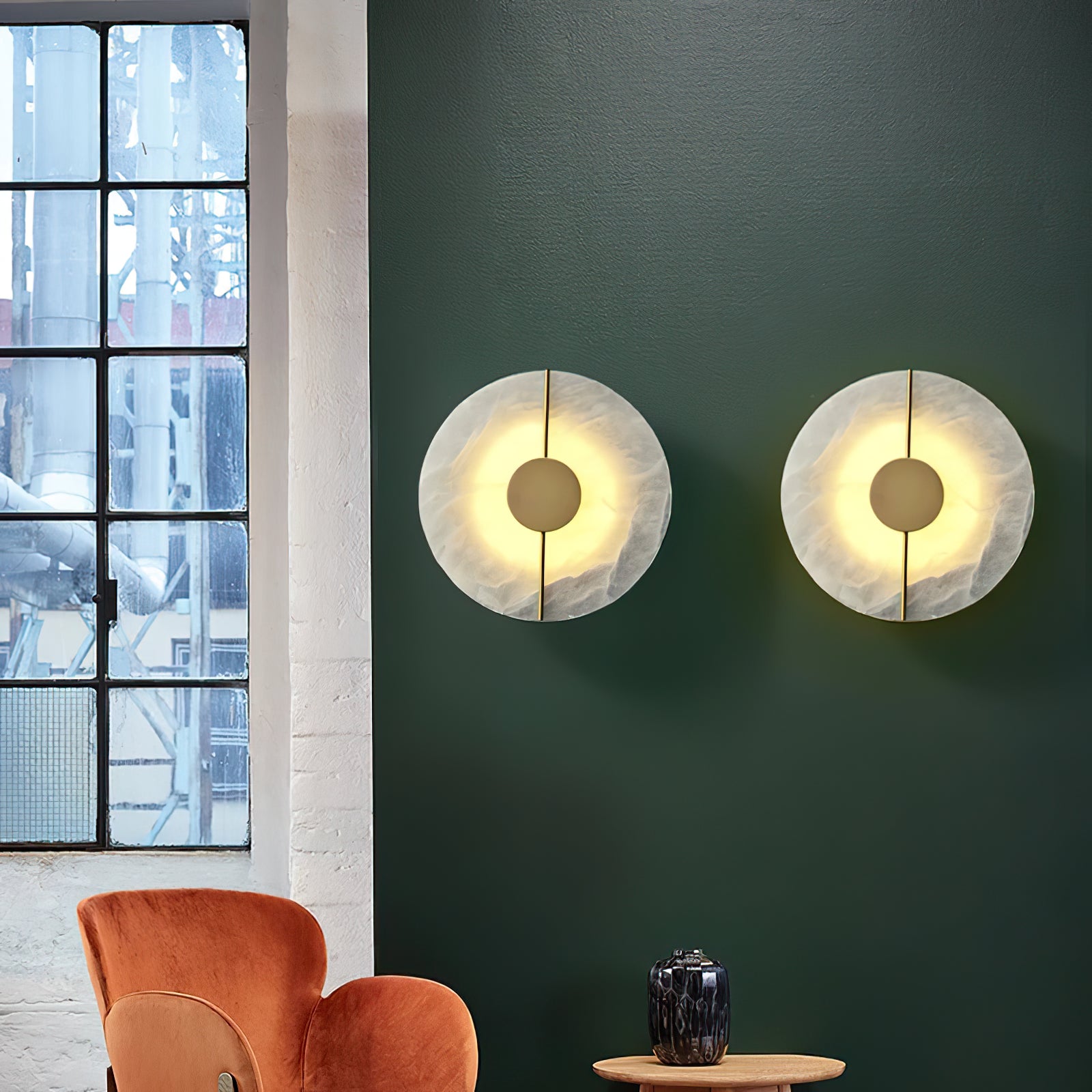 Pair of round marble-and-brass lights on a green wall