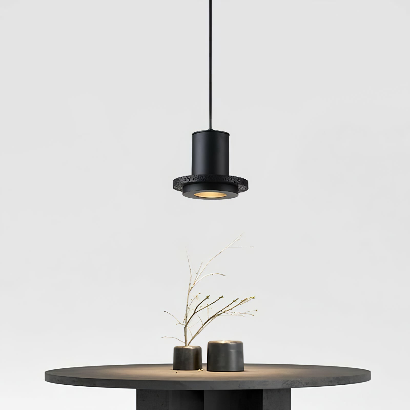 Small black pendant with a narrow rim above a round table