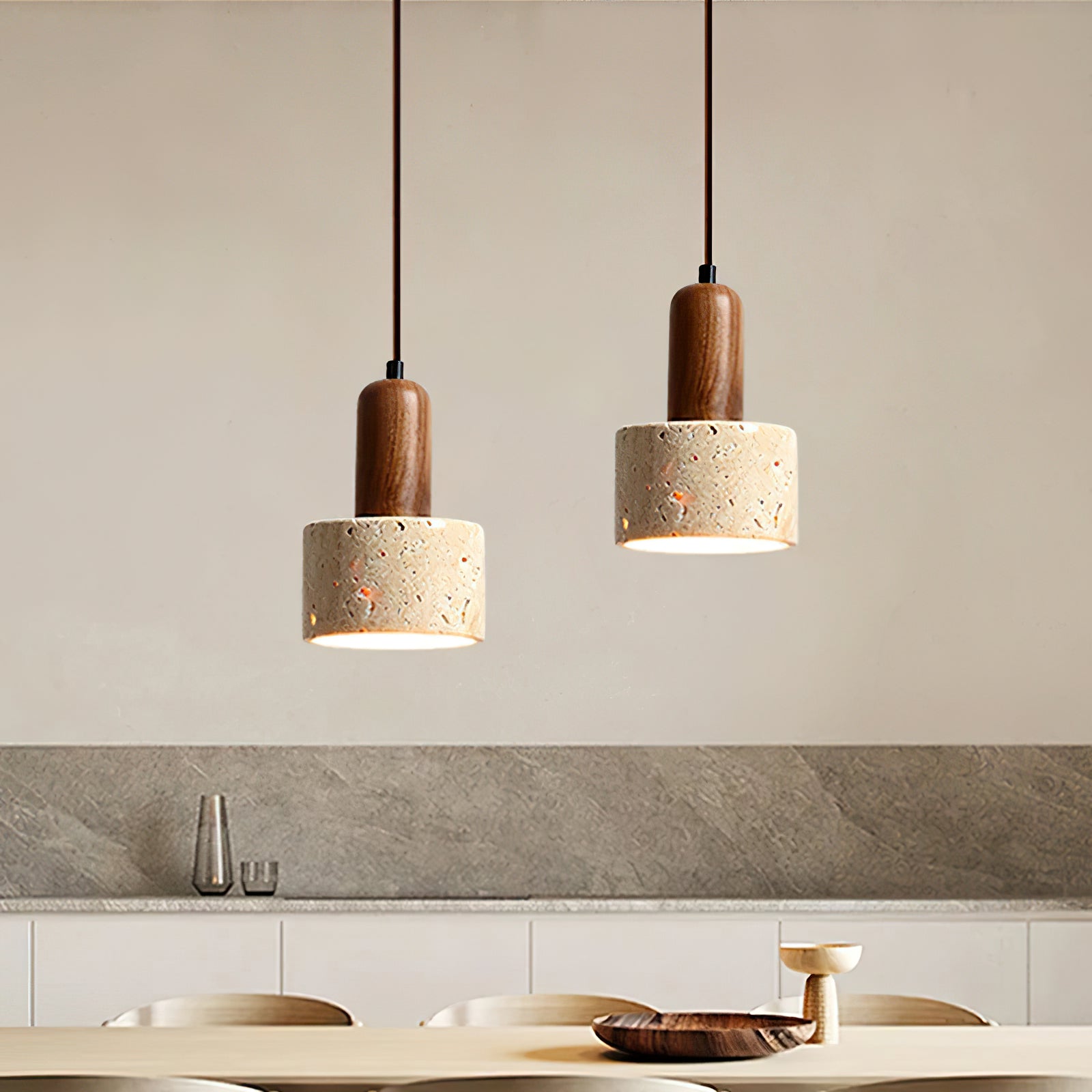 Two stone cylinder pendants above a dining table