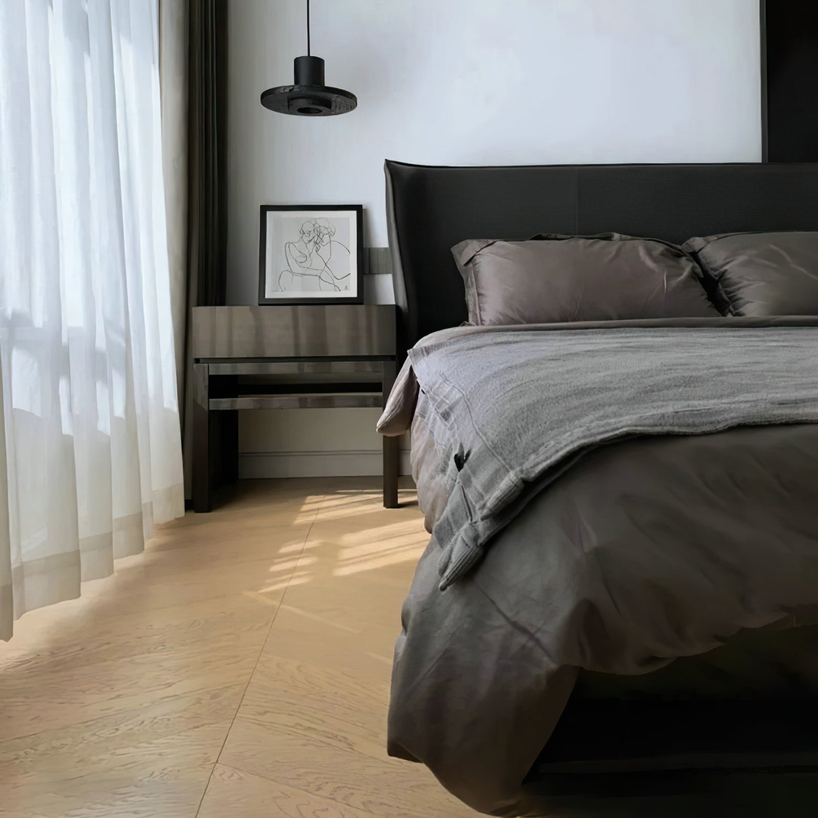 Black disc pendant above a nightstand by sheer curtains