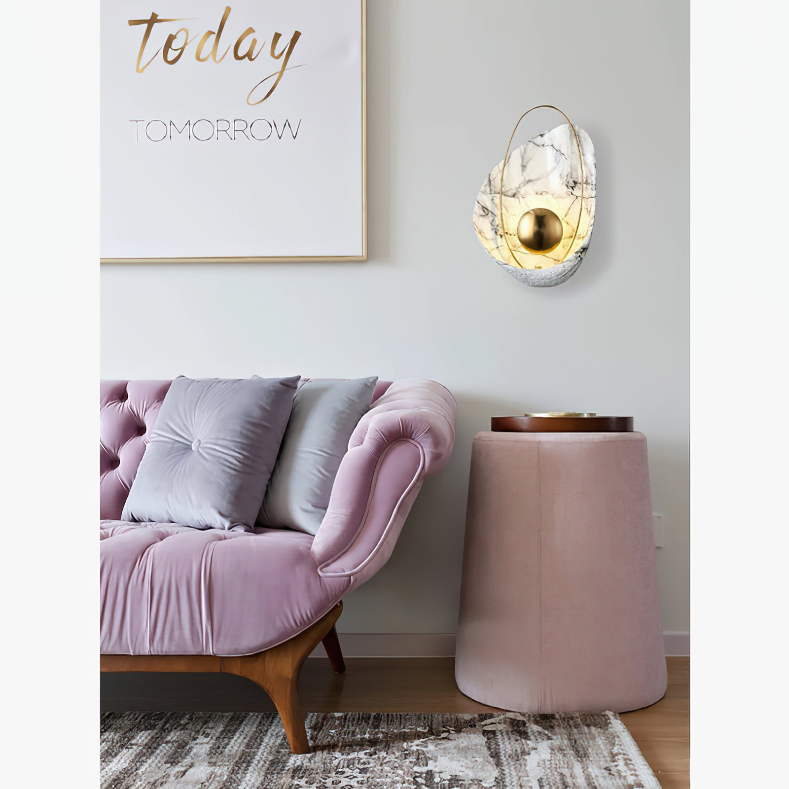Shell wall light above a side table beside pink seating