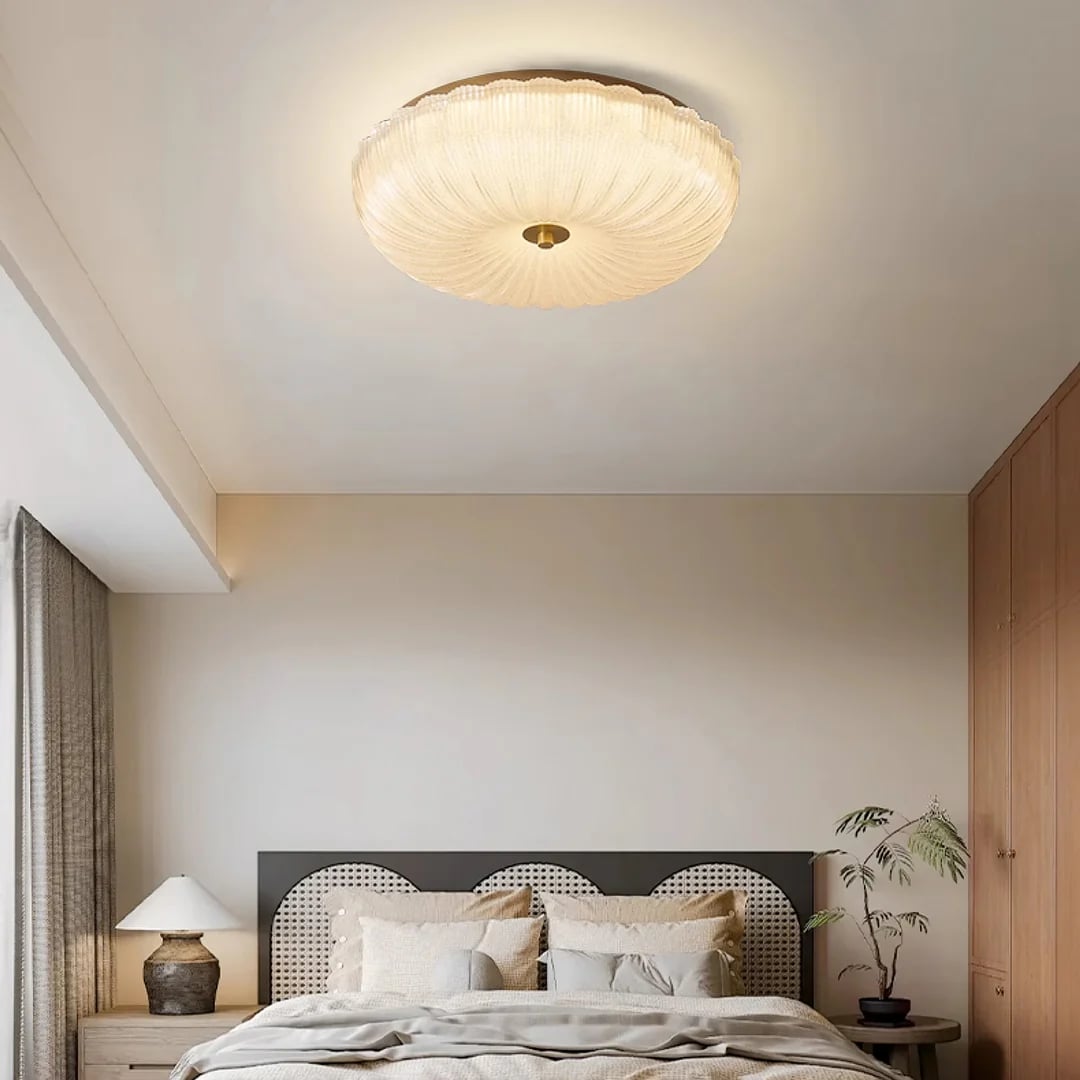 Warm-looking glass ceiling fixture near a bedroom wall