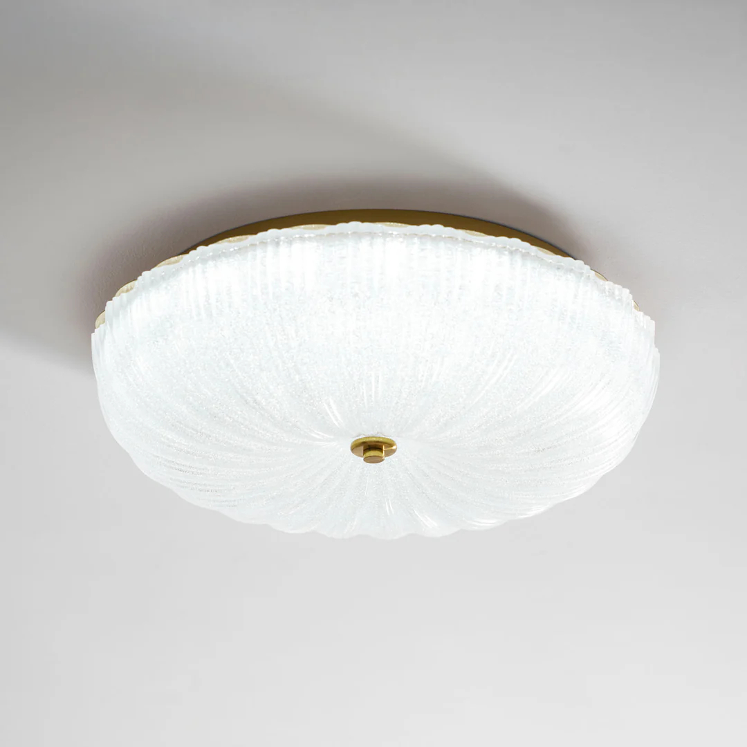 Brightly lit ribbed glass bowl viewed from below