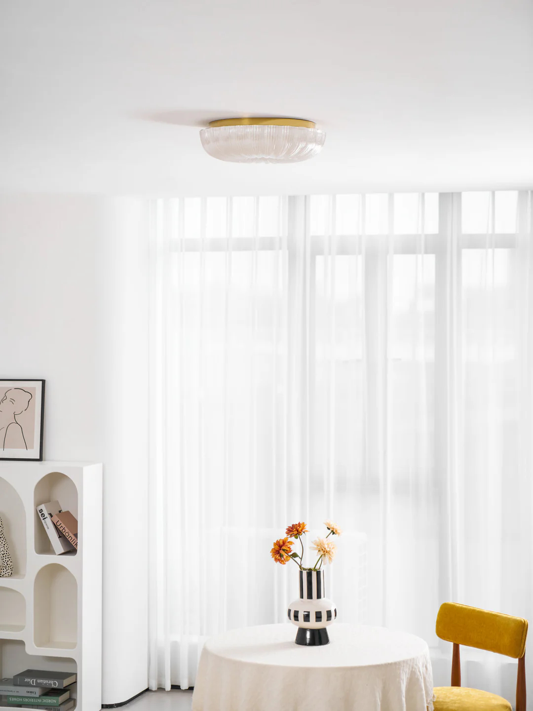 Gold-trim glass fixture in a bright dining room