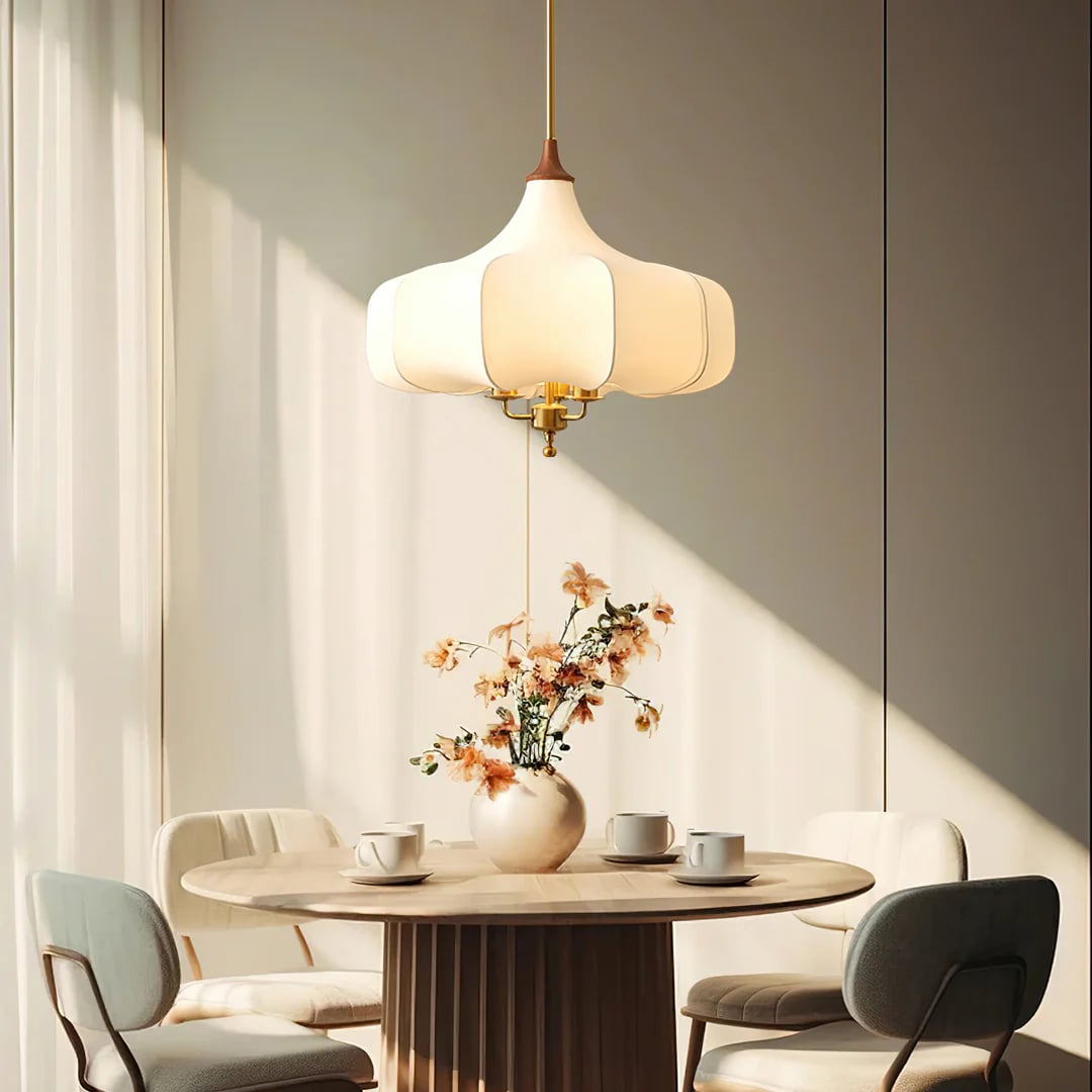 White layered pendant seen from the side over a dining table