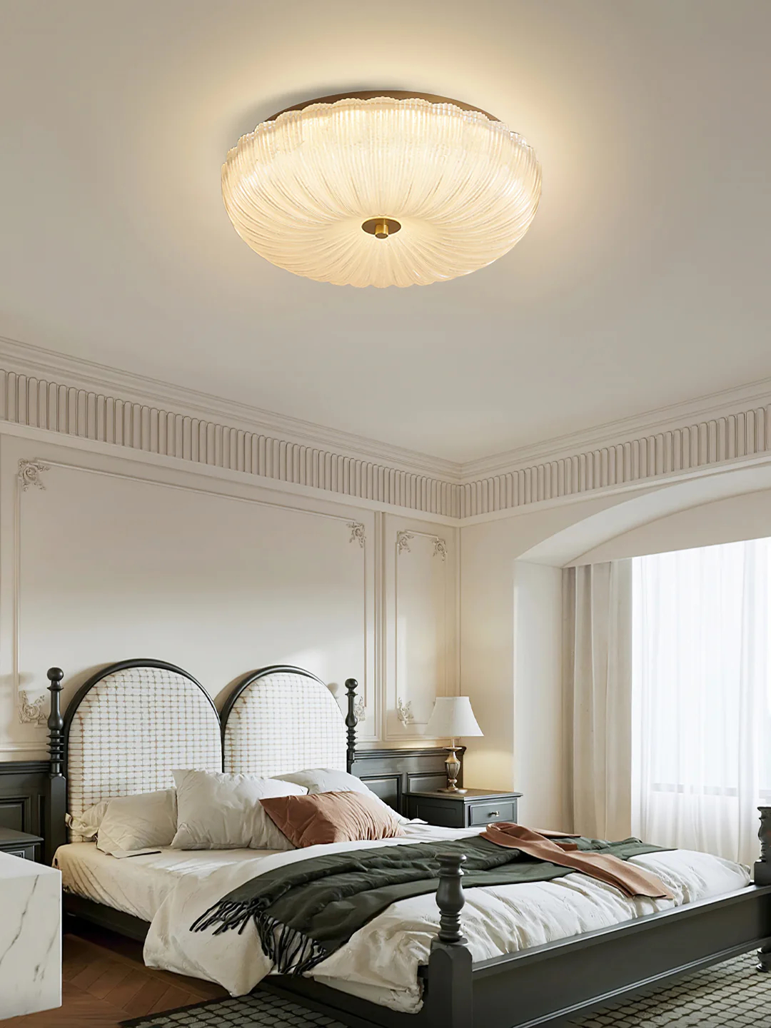 Ripple ceiling light above a dark metal bed frame