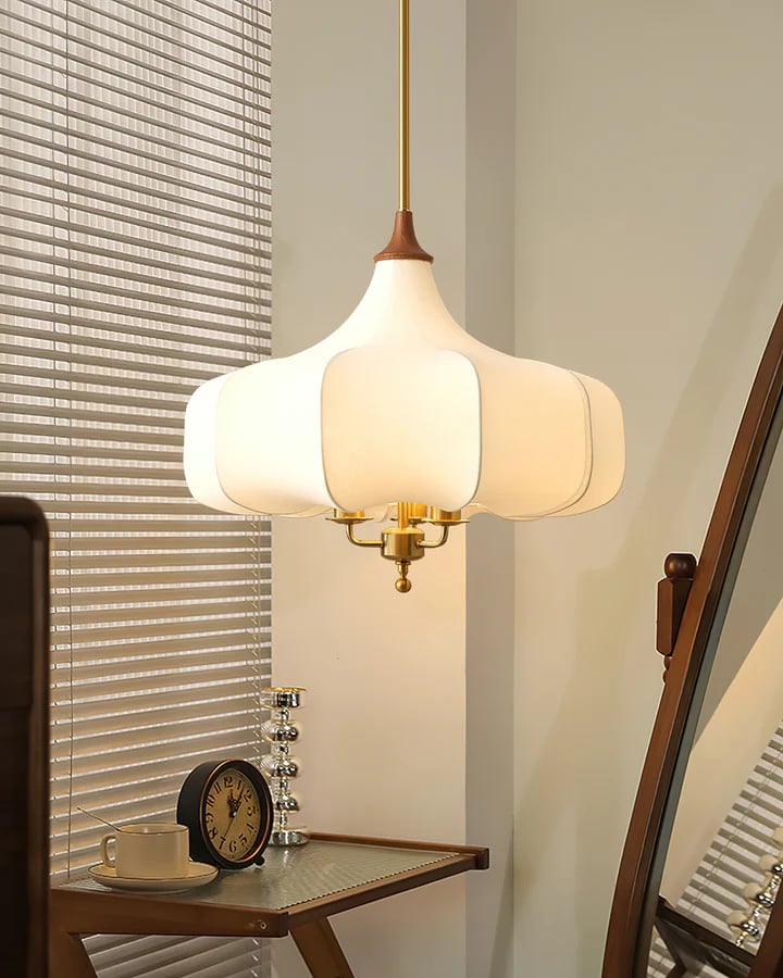 Plain white pendant beside window blinds and a small table clock
