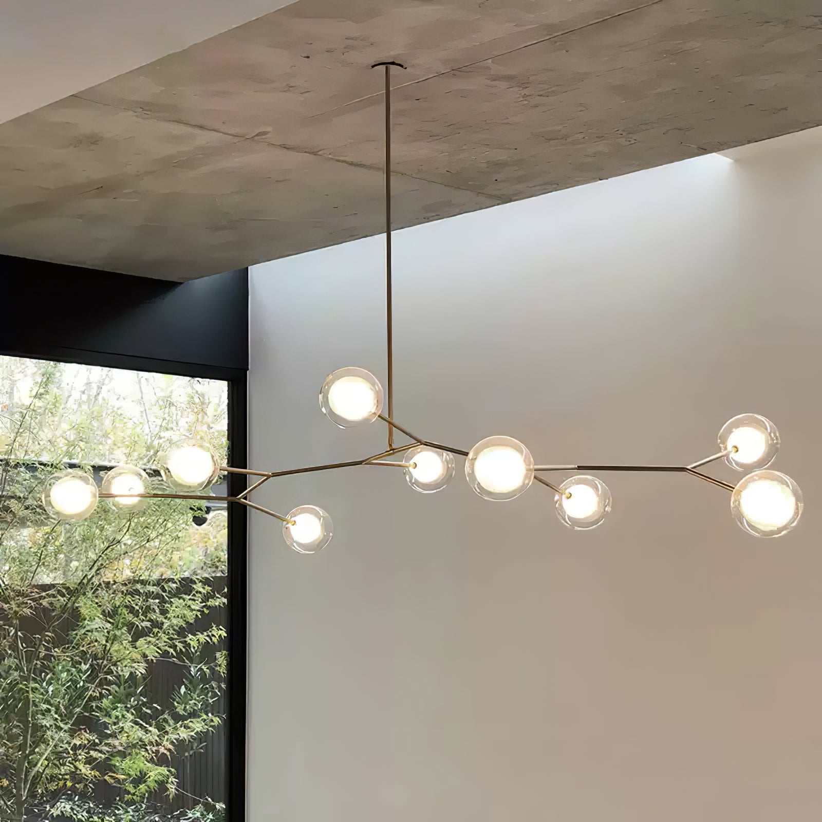 Gold branch chandelier beneath a concrete ceiling