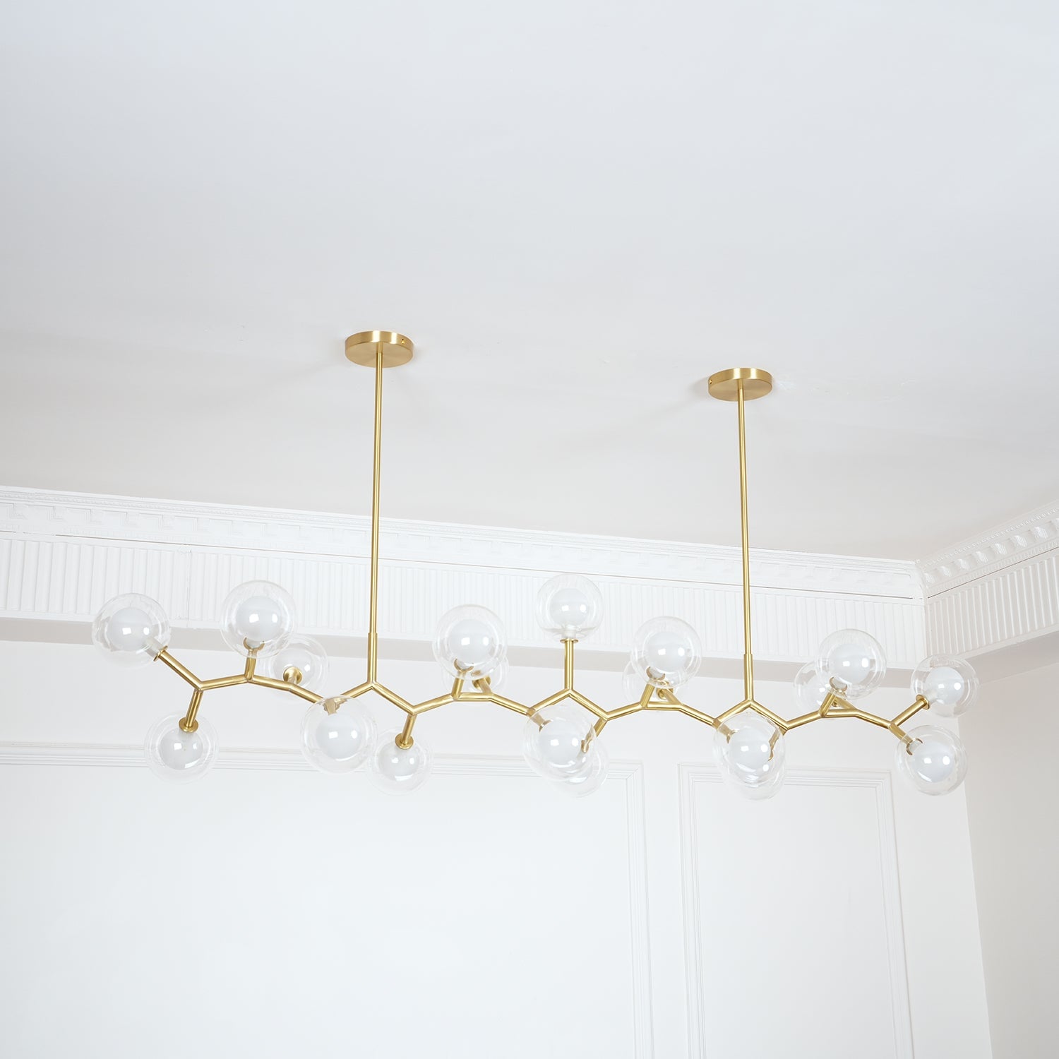 Clear glass globe chandelier against pale wall mouldings