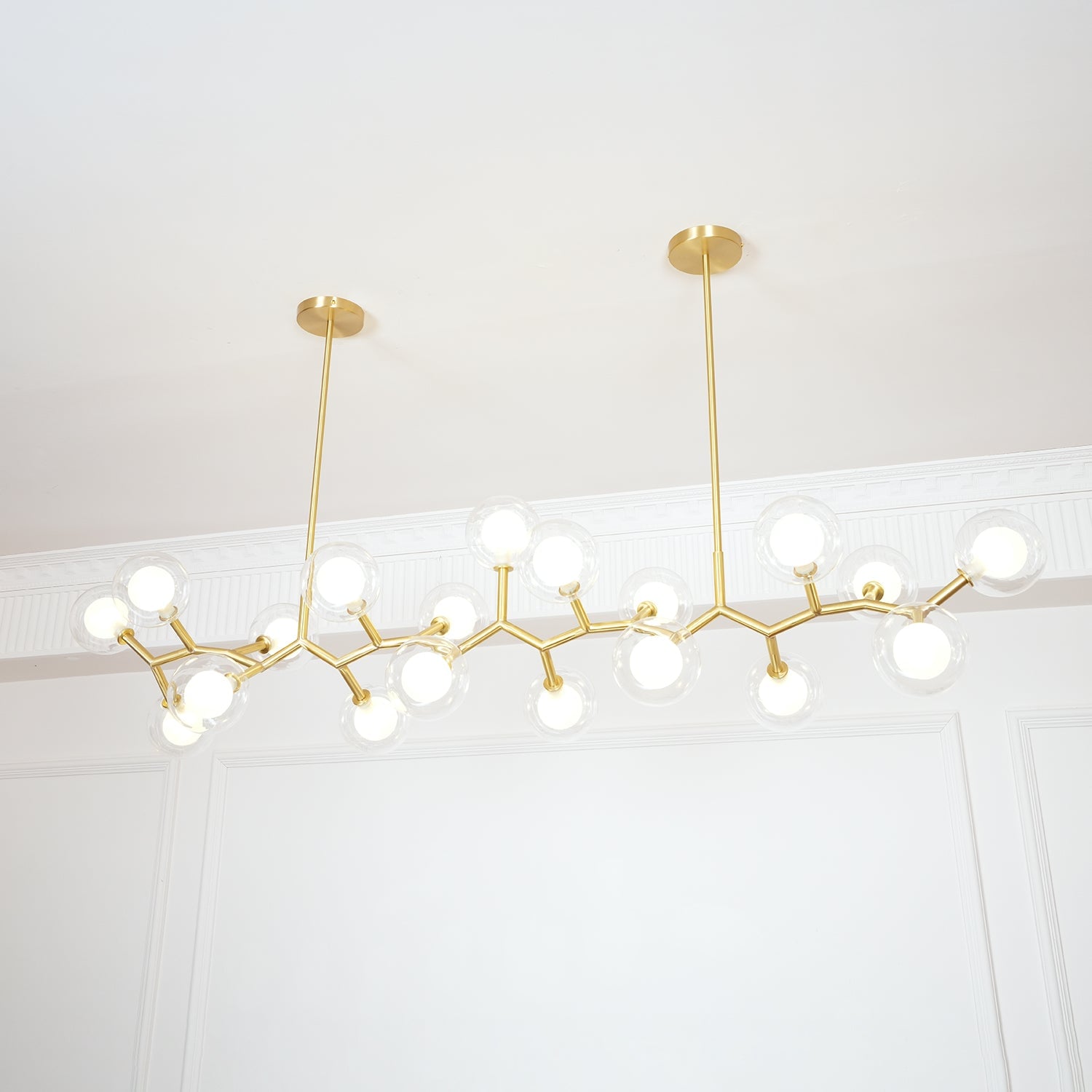 Long lit chandelier with glass globes and two ceiling rods