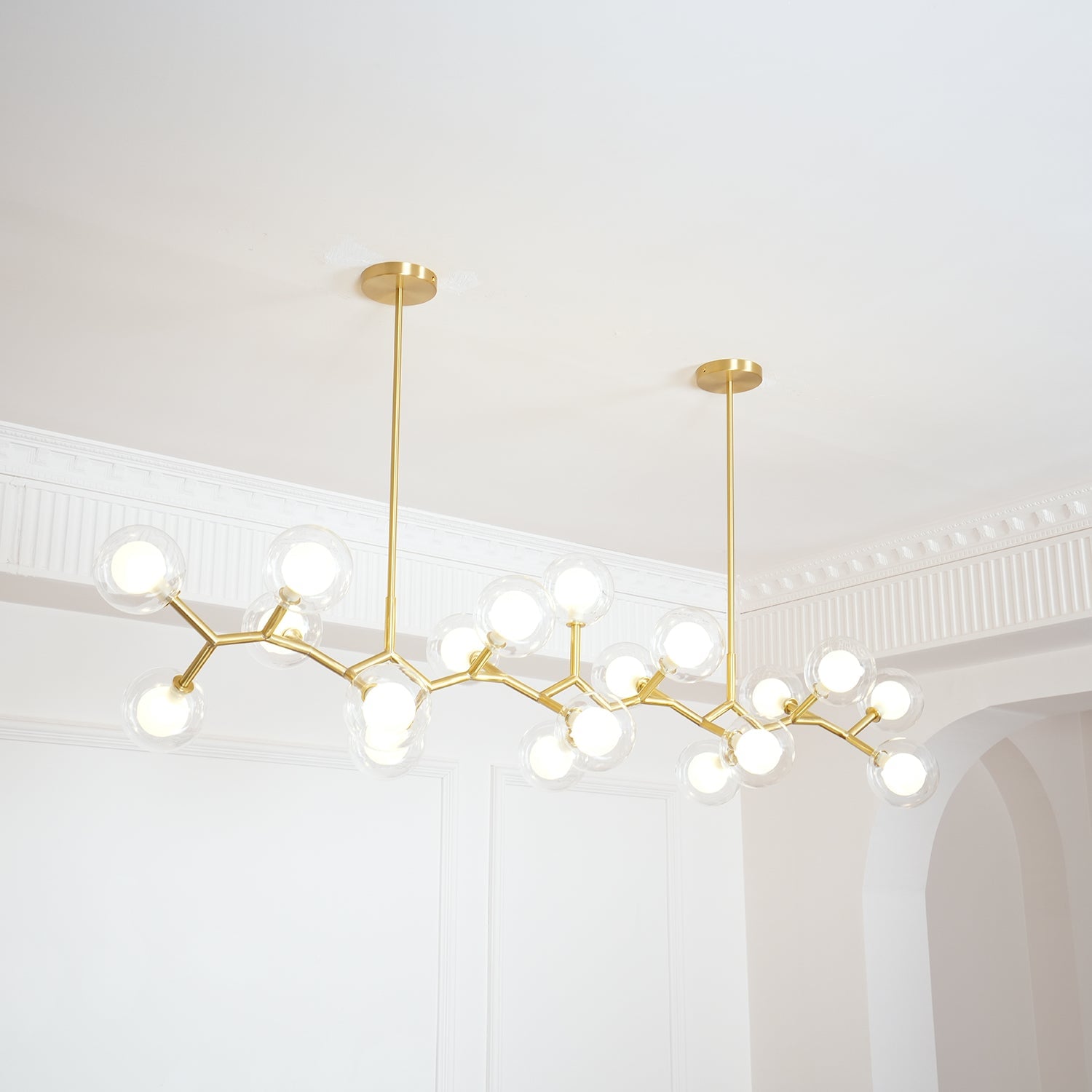 Angled view along the illuminated glass globes and gold frame